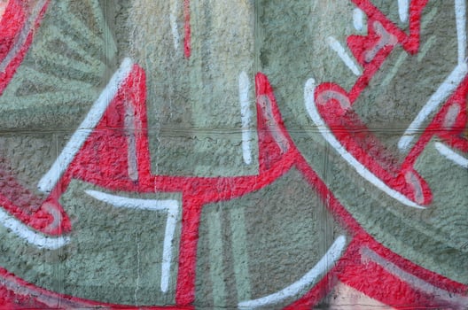 Fragment of graffiti drawings. The old wall decorated with paint stains in the style of street art culture. Colored background texture in warm tones photo