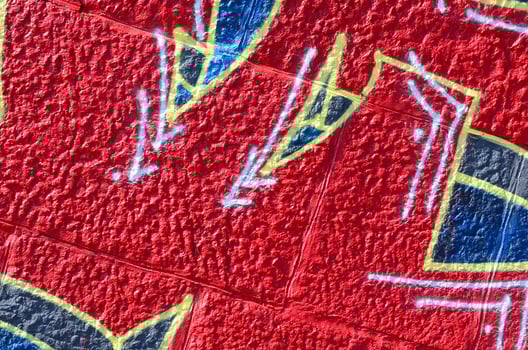 Fragment of graffiti drawings. The old wall decorated with paint stains in the style of street art culture. Colored background texture in warm tones photo