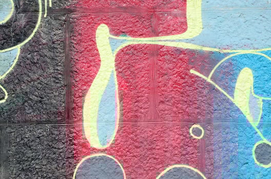 Fragment of graffiti drawings. The old wall decorated with paint stains in the style of street art culture. Multicolored background texture photo
