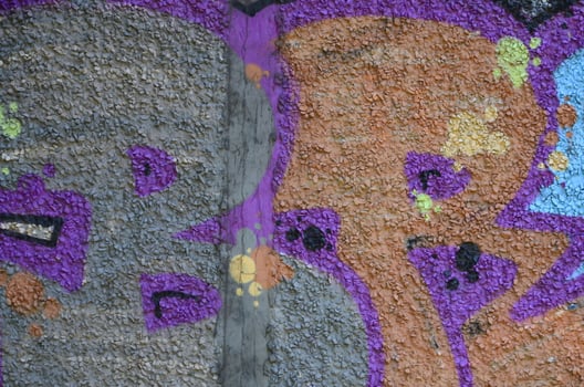 Fragment of graffiti drawings. The old wall decorated with paint stains in the style of street art culture. Colored background texture in warm tones photo