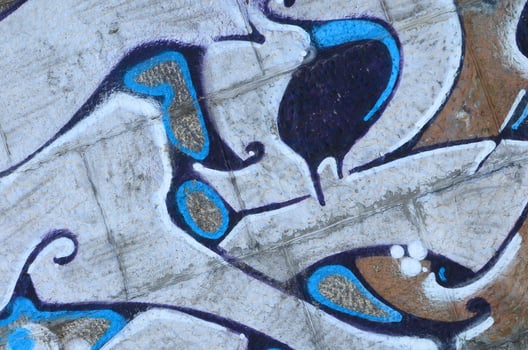 Fragment of graffiti drawings. The old wall decorated with paint stains in the style of street art culture. Colored background texture in warm tones photo