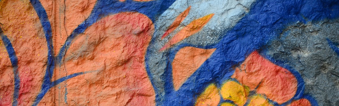 Fragment of graffiti drawings. The old wall decorated with paint stains in the style of street art culture. Orange flower photo