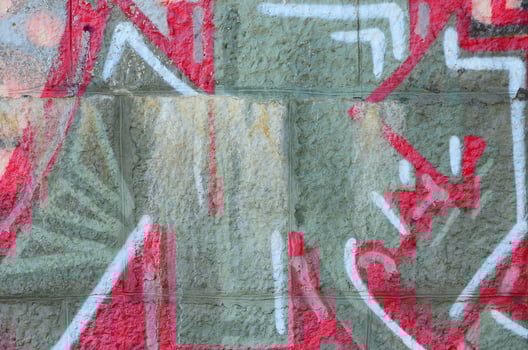 Fragment of graffiti drawings. The old wall decorated with paint stains in the style of street art culture. Colored background texture in warm tones photo