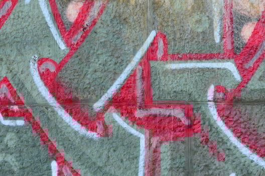 Fragment of graffiti drawings. The old wall decorated with paint stains in the style of street art culture. Colored background texture in warm tones photo