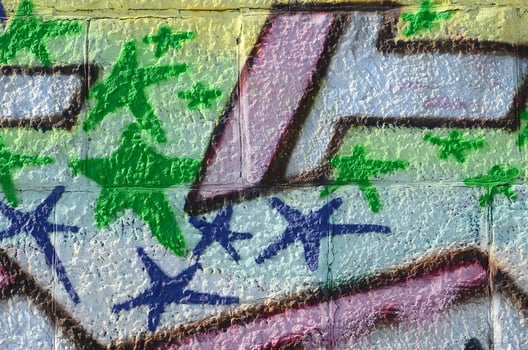 Fragment of graffiti drawings. The old wall decorated with paint stains in the style of street art culture. Colored background texture in green tones photo