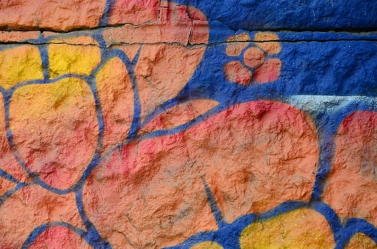 Fragment of graffiti drawings. The old wall decorated with paint stains in the style of street art culture. Orange flower photo