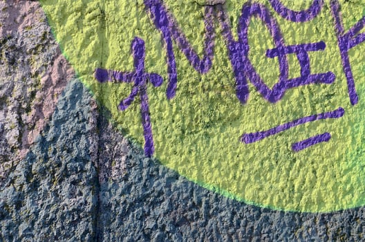 Fragment of graffiti drawings. The old wall decorated with paint stains in the style of street art culture. Colored background texture in warm tones photo
