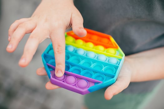 Pop it fidget toy in girl hand's. Colorful antistress kid's toy fidget photo