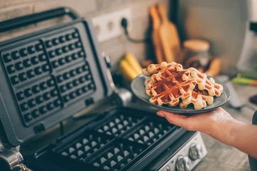 Young woman holding in hands plate with Belgian waffles photo