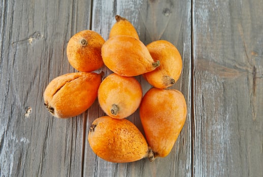 Medlar ripe, Loquats fruits Group of Japanese orange fruit medlars, exotic, juicy sweet plums on wooden background photo