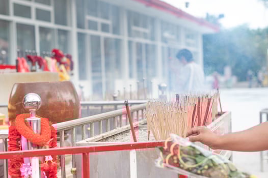 Male putting incense in the pot to pay for buddhist in the temple of Thailand. photo