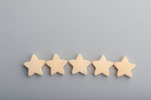 Five wooden stars on gray background.Copy space. photo