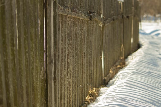 Fence made of wood in winter. Wooden fence in countryside. photo