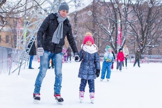Adorable little girl and happy dad on skating rink outdoor photo