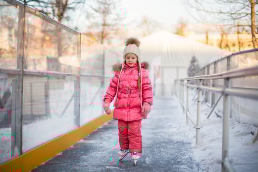 Adorable little girl enjoying skating at the ice-rink photo