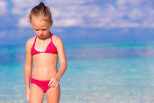 Adorable little girl at beach during summer vacation photo
