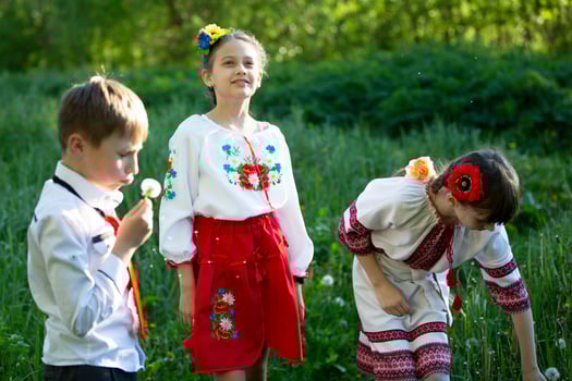 Ukrainian or Belarusian children in embroidered shirts play in the meadow. photo