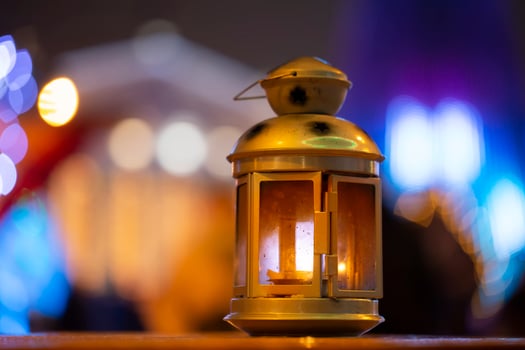 Golden vintage lantern on evening bokeh background.Yellow lantern on a bench at night. The background is blurred. Old lantern. Evening light. Bokeh photo