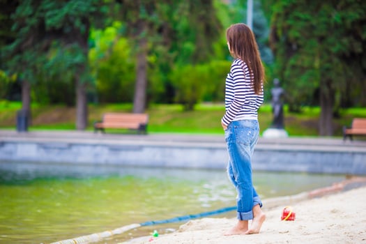 Young happy woman walking near the lake at warm autumn day photo