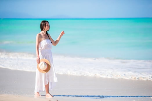 Young happy woman in hat on white beach having fun photo