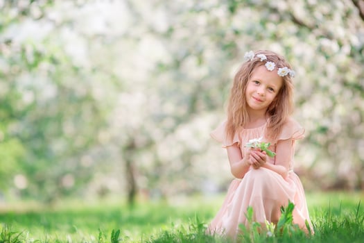 Little girl in blooming cherry tree garden outdoors photo