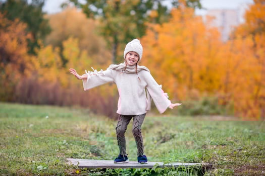 Adorable little girl at beautiful autumn day outdoors photo