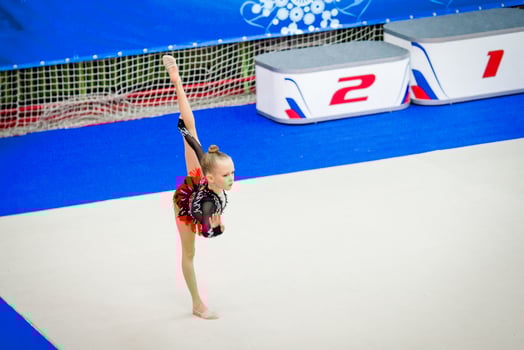 Adorable gymnast participates in competitions in rhythmic gymnastics photo