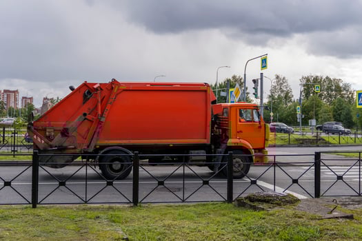 a garbage truck is driving through the city photo