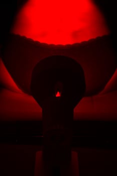 Woman sitting on chair with a heat lamp on her lower back photo
