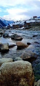 A river with rocks and snow on the shore photo