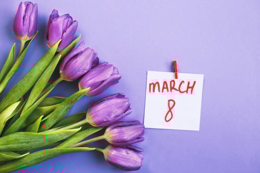 Purple bouquet of flowers tulips background with a note March 8 on veri peri background. photo