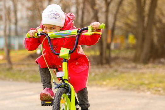Child riding bike. Kid on bicycle in sunny park. Little girl enjoying bike ride her way to school on warm summer day. Preschooler learning to balance on bicycle in safe helmet. Sport for kids. photo