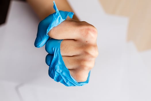 Hand wearing torn plastic protective glove photo