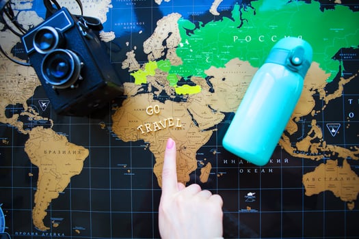 Map of the world in Russian. The finger of the girl points to different corners of the world. photo
