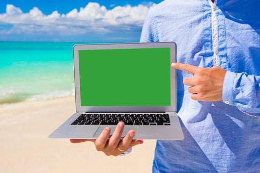 Young man with laptop during beach vacation photo
