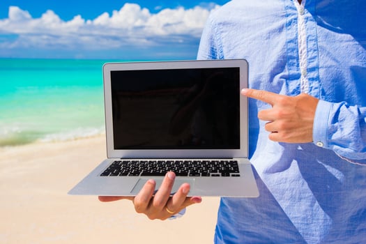 Young man with laptop during beach vacation photo