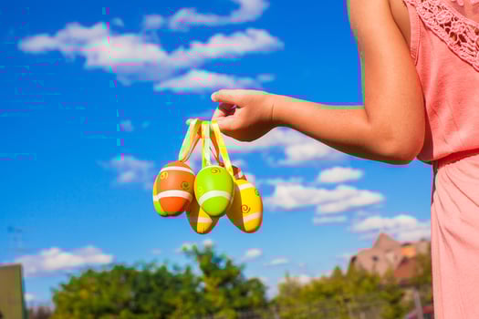 Closeup hand of a little girl holding colorful Easter eggs background the blue sky photo