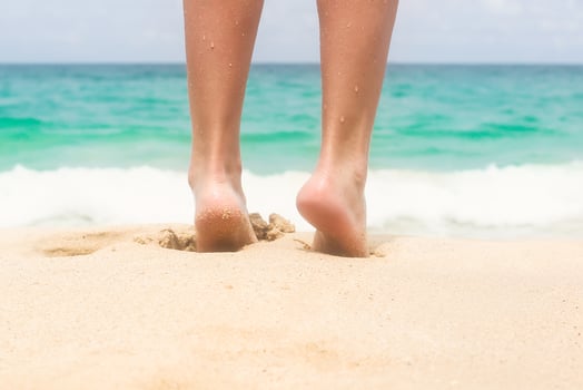 Women's beautiful legs on white sandy beach photo
