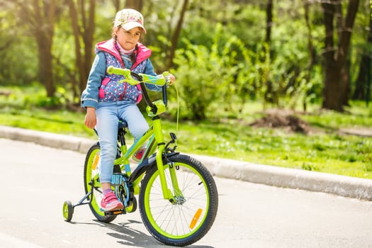 Child on a bicycle at asphalt road in summer. Bike in the park photo