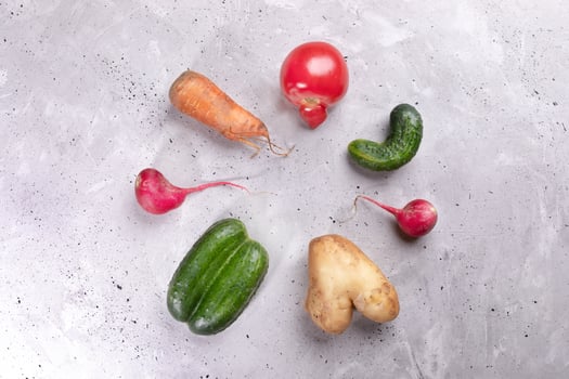 Set of ugly vegetables laid out in circle on concrete background. photo