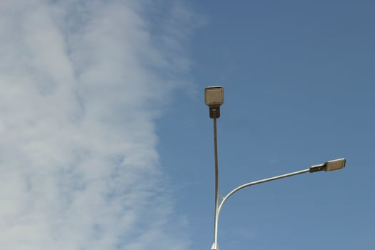 Street light during day. Pole with lamp. Urban electricity. photo