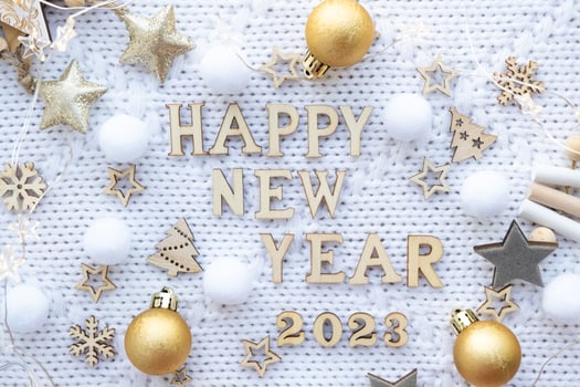 Happy New Year-wooden letters and the numbers 2023 on festive white knitted background with sequins, stars, lights of garlands. Greetings, postcard. Calendar, cover photo