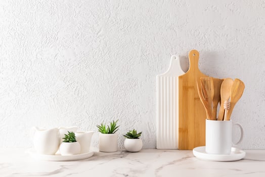 environmentally friendly items of modern tableware on a white marble countertop with green plants in mini-hills. space for text. minimalist style. photo