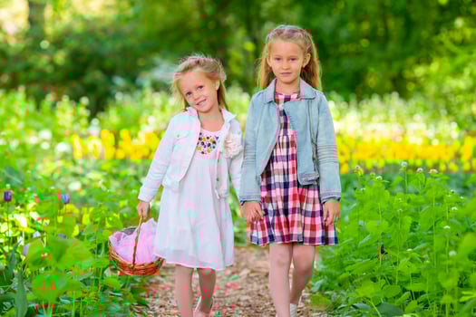 Little adorable girls walking in spring garden outdoors photo