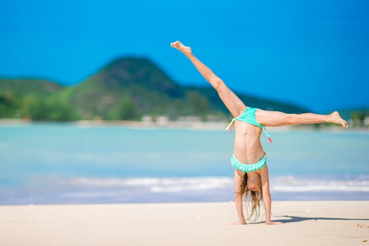 Adorable active little girl at beach during summer vacation photo