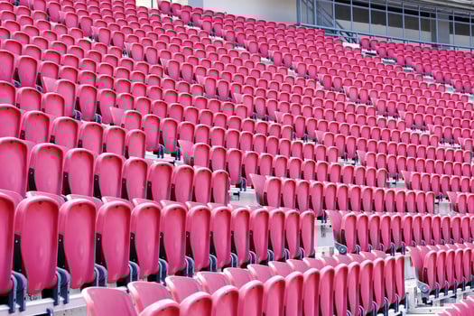 Pink plastic chairs on the grandstand watching football matches at large stadium. photo