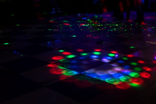 Disco on dance floor. Flower spots on floor. Color music indoors. photo
