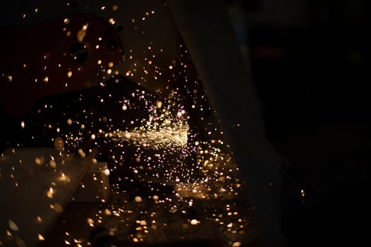 Lights are flying in all directions. Sparks from saw. Lights in dark. photo