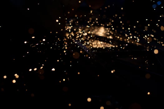 Metal grinding. Sparks from friction. Lights in dark. Chaotic flight of partial fire. photo