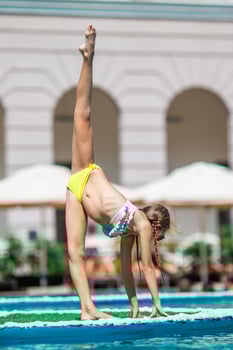 Beautiful little girl having fun near an outdoor pool photo